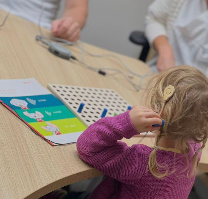 Kind mit Cochlea Implantat nimmt an einem Hörtest teil.
